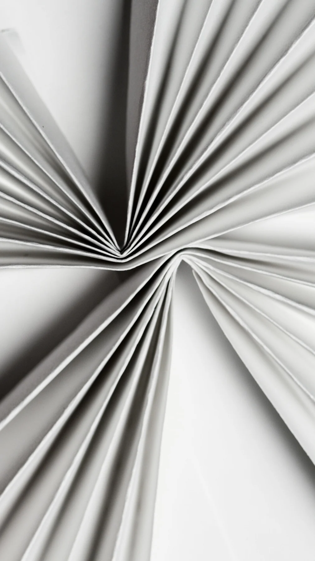 Folded sheets of paper creating a flowing monochrome composition