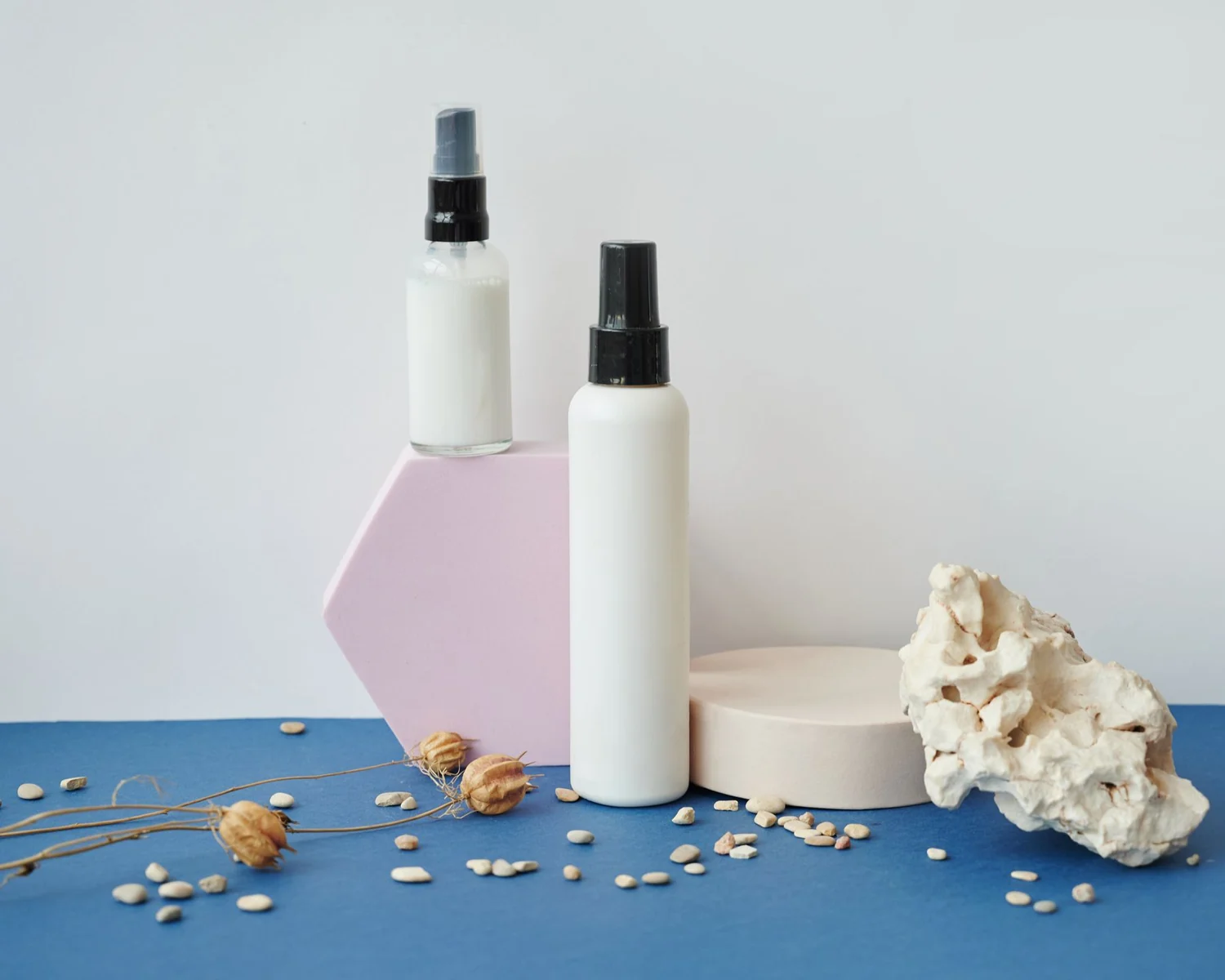 Unbranded bottles arranged with tactile stone and sculptural forms